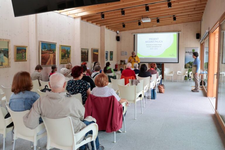 Udeleženci usposabljanja za spremljevalce na Poti za spomin v prireditvenem paviljonu Arboretuma Volčji Potok spremljajo predavanje.