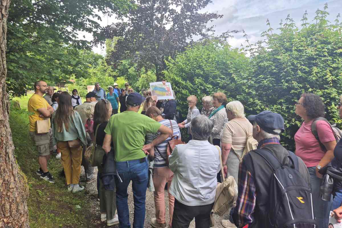 Vodeni ogled grajskega vrta Loškega muzeja Skupina obiskovalcev med vodenim ogledom grajskega vrta Loškega muzeja Škofja Loka posluša predstavitev ob fotografskem gradivu.