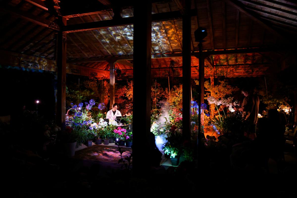 Cvetlični orkester pod Indonezijskim paviljonom. Foto: Katja Goljat Širok pogled na prizorišče Cvetličnega orkestra pod Indonezijskim paviljonom z rastlinami, svetlobnimi učinki in izvajalcem.