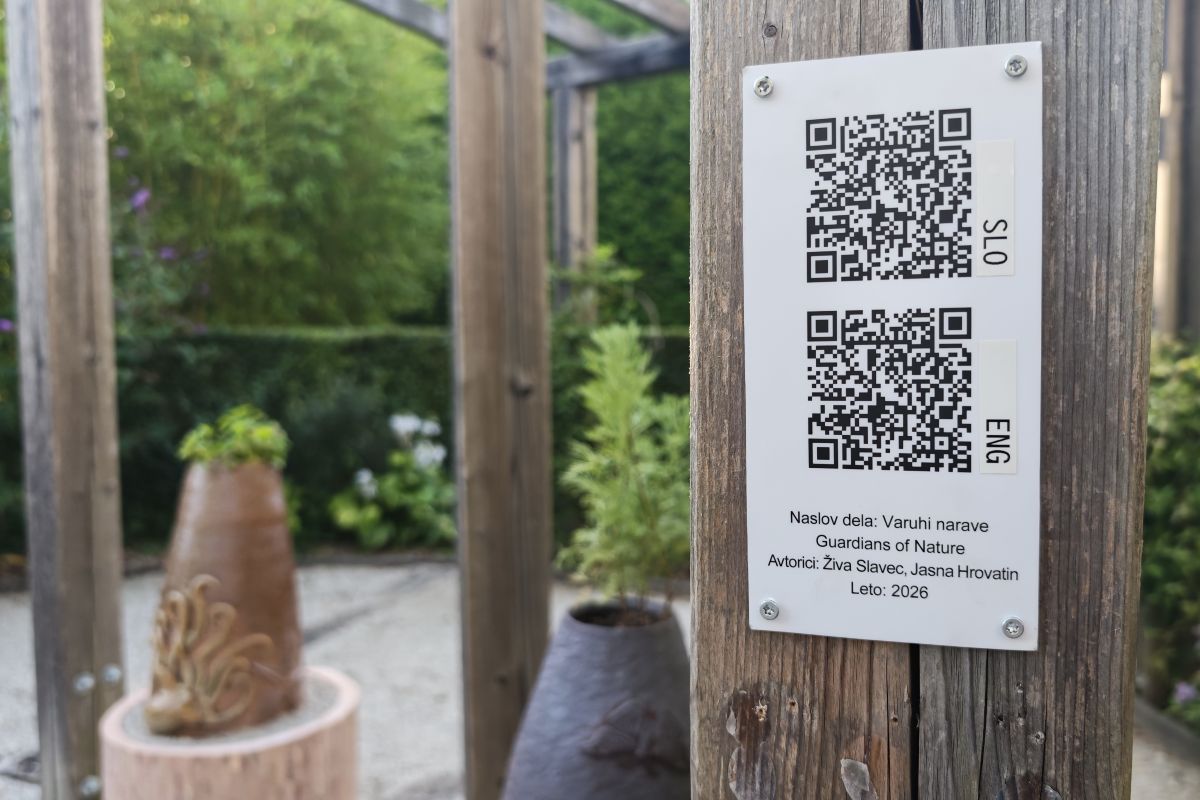 QR-koda z zvočno predstavitvijo skulpture Varuhi narave Informacijska tablica z dvema QR-kodama za zvočno predstavitev skulpture Varuhi narave v slovenščini in angleščini.